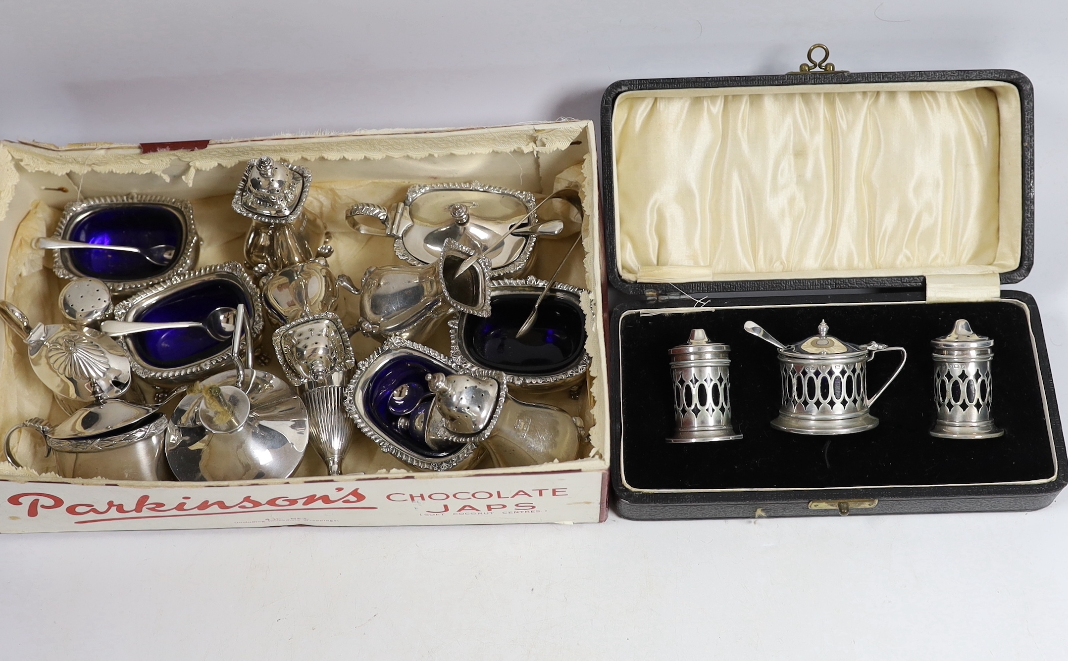 A George V silver nine piece condiment set, by Harrod's Ltd, Birmingham, 1933, a cased three piece silver condiment set and six other items including condiments and a table perpetual lighter.